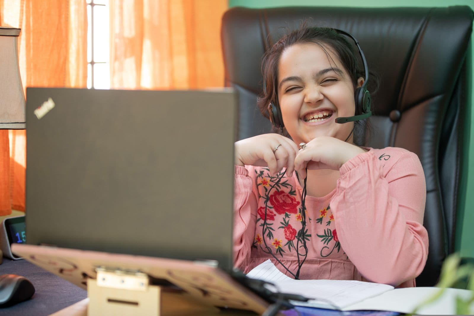 A smiling girl enjoying an online maths class at home